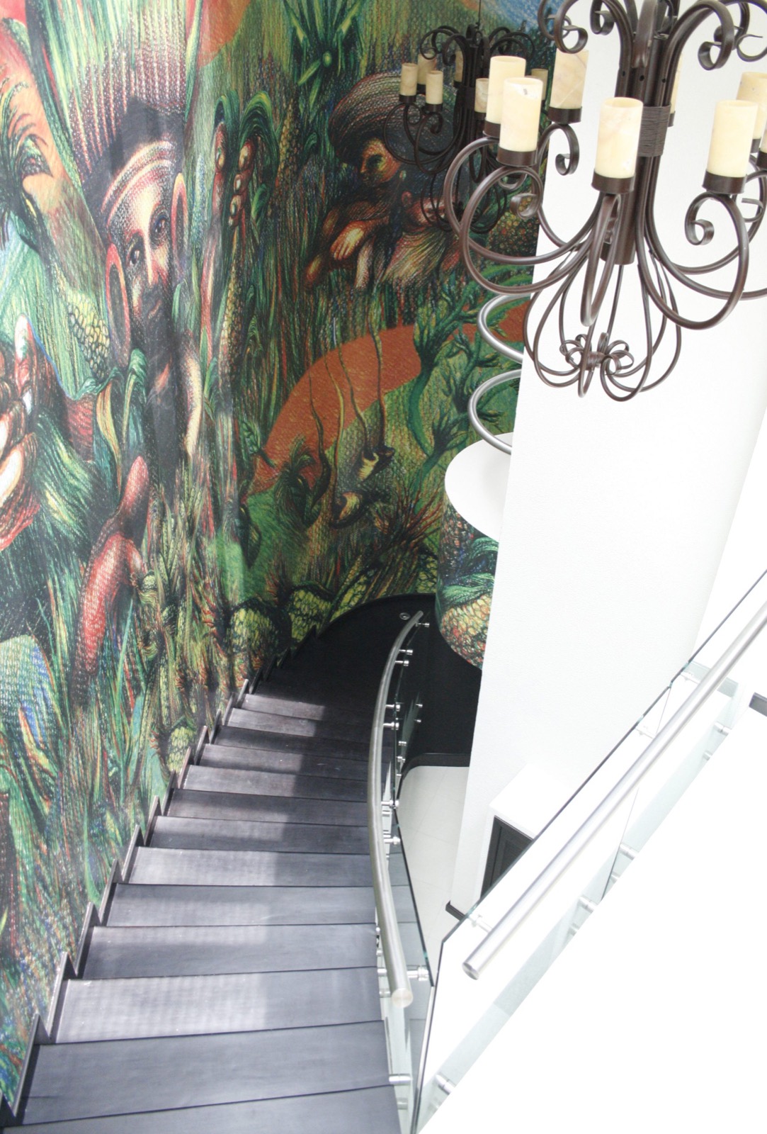 Escalera interior acompañada por el mural de Quipán